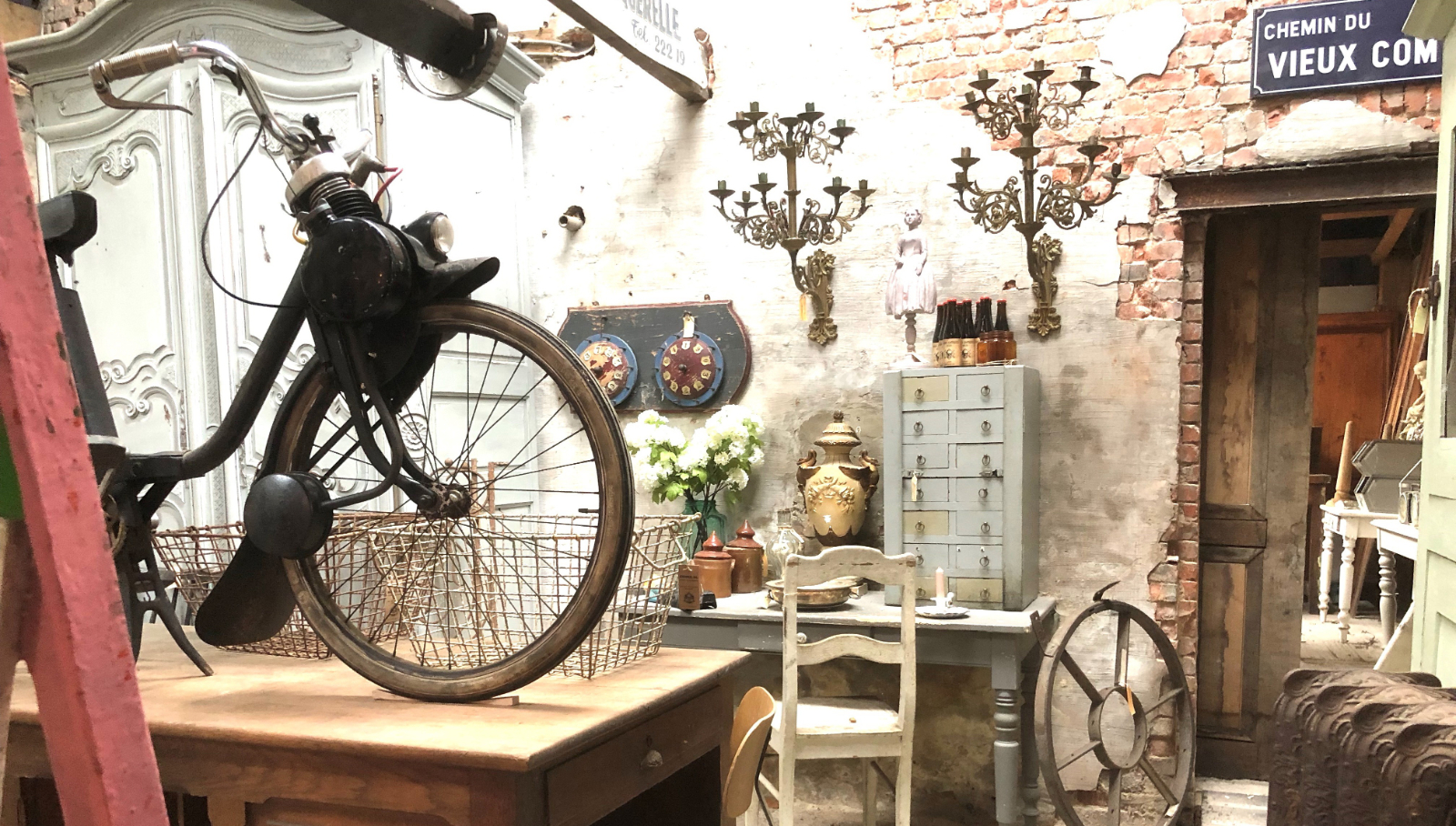 Brocante winkelinterieur met vintage fiets en antieke kast